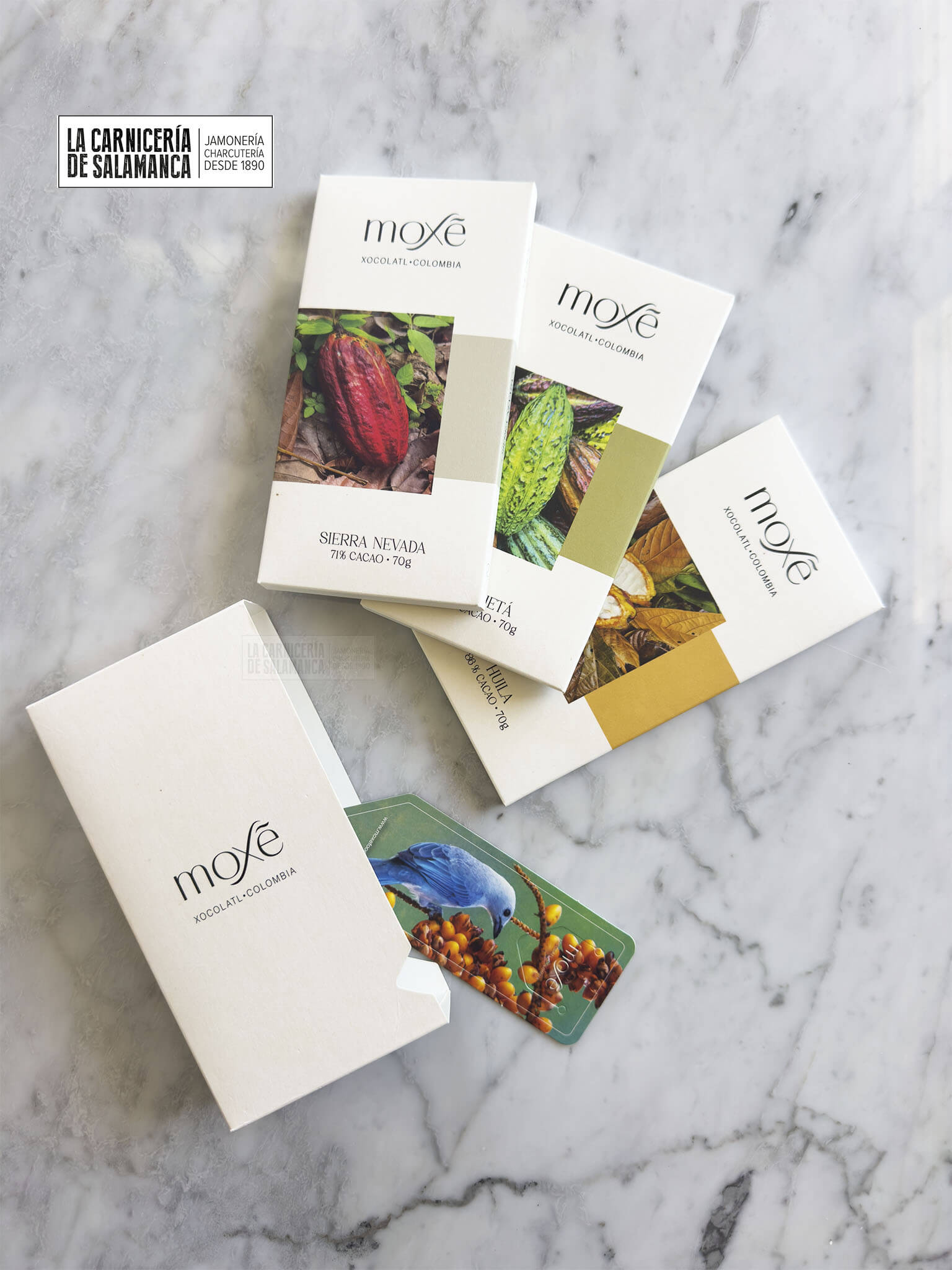 Chocolates Moxé de Colombia, disponibles en La Carnicería de Salamanca. Tabletas gourmet con cacao 71%, 83% y 86% de la Sierra Nevada, Huila y Caquetá. Presentación premium en pack de diseño elegante con marca páginas incluido. Perfectos para los amantes del chocolate negro de alta calidad. Compra online y disfruta de un producto sostenible y responsable, apoyando a comunidades productoras. Envío en frío garantizado desde nuestra carnicería online.