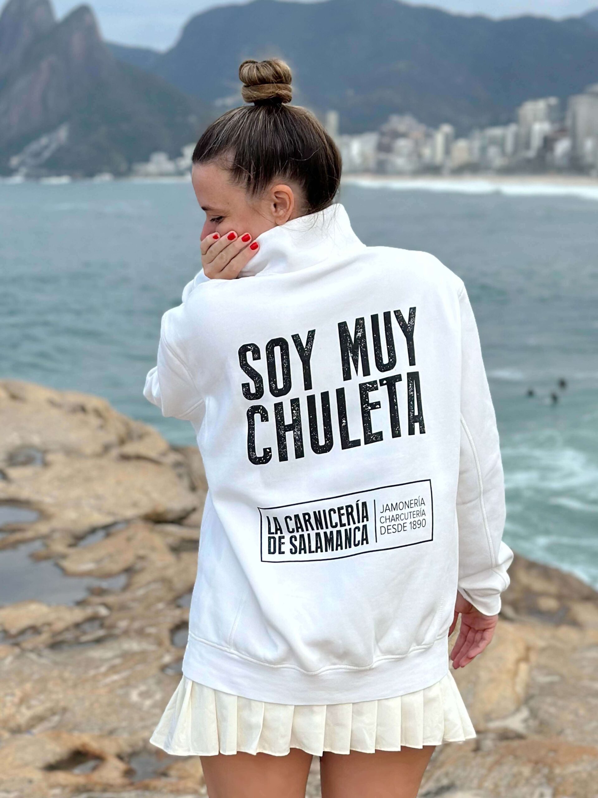 María Hernández Mesonero con sudadera blanca de MUY CHULETA® mostrando el mensaje “SOY MUY CHULETA” y el logo de LA CARNICERÍA DE SALAMANCA en la parte posterior. La imagen captura el espíritu auténtico de la marca MUY CHULETA® de LA CARNICERÍA DE SALAMANCA, una prenda de alta calidad con diseño exclusivo, perfecta para quienes buscan un estilo único y personal.
