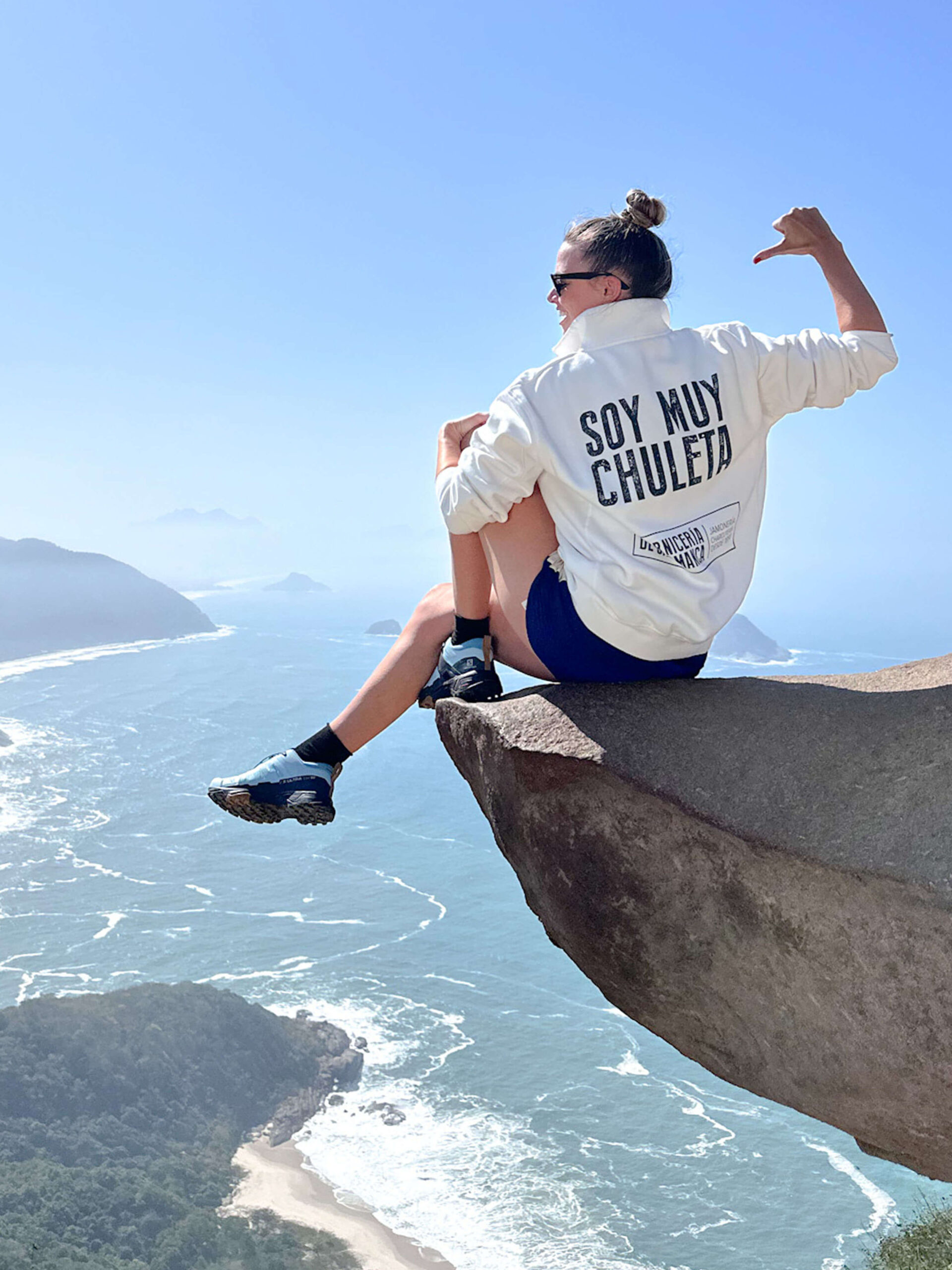 María Hernández Mesonero de LA CARNICERÍA DE SALAMANCA en la Pedra do Telegrafo en Río de Janeiro, llevando la sudadera oficial de MUY CHULETA® con el mensaje “SOY MUY CHULETA” y el logo de LA CARNICERÍA DE SALAMANCA. Escena que resalta la esencia de la marca MUY CHULETA® y su vínculo con LA CARNICERÍA DE SALAMANCA, una prenda única para quienes buscan estilo y autenticidad.