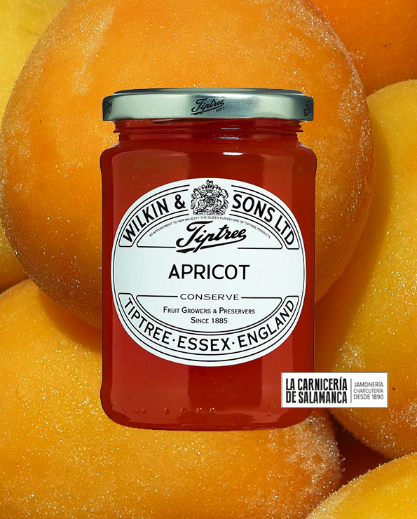 Tarro de mermelada de albaricoque Tiptree con fondo de albaricoques maduros. Producto artesanal disponible en La Carnicería de Salamanca, Peñaranda de Bracamonte.
