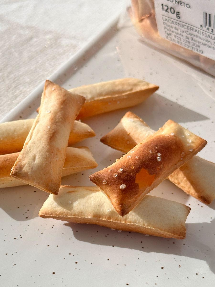 Pan soplado artesanal con aceite de oliva, crujiente y ligero, elaborado para La Carnicería de Salamanca, ideal para acompañar jamón, quesos y embutidos.